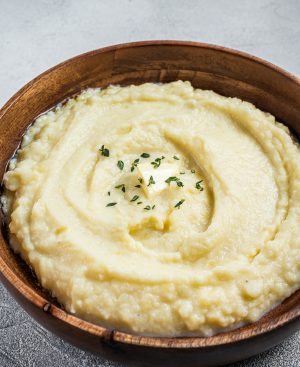 Boiled potato puree, Mashed potatoes in a wooden plate. White background. Top view